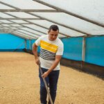 Producer Elkin Guzmán raking Washed coffee beans