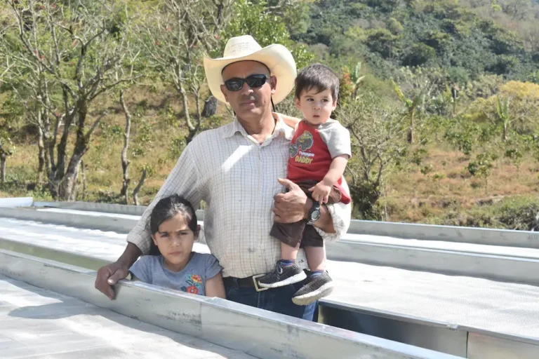 Coffee producer Remiery Orlando Carabajal by drying beds at his farm La Casa in Honduras with his family