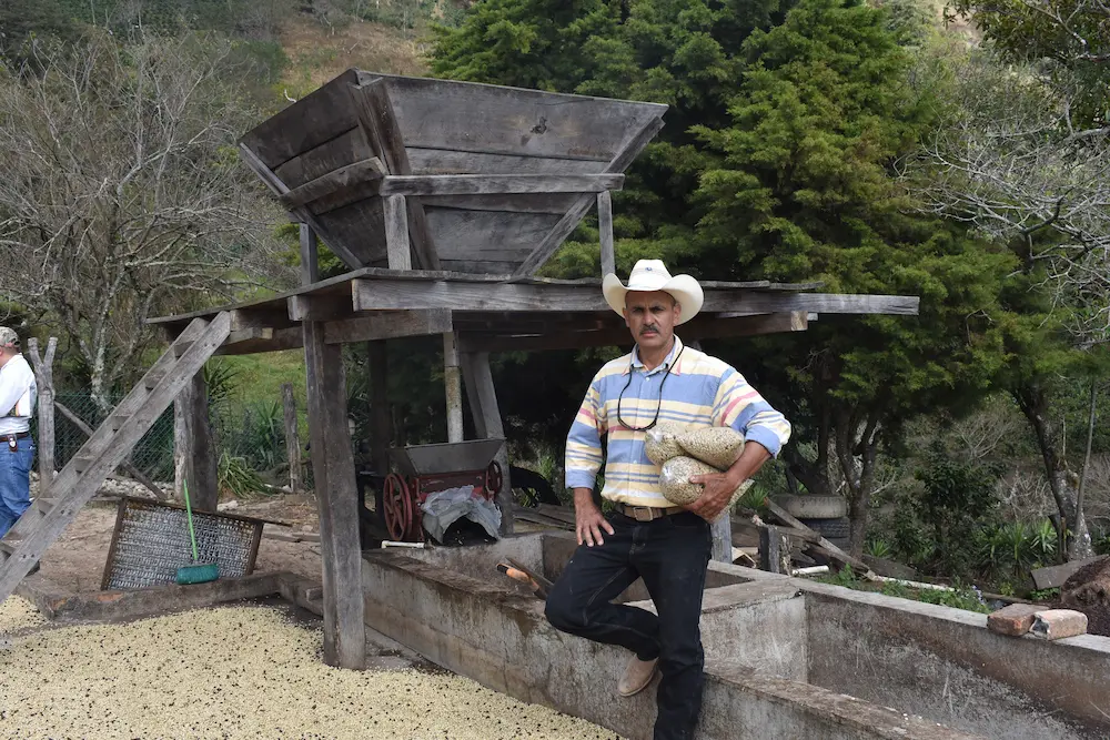 Coffee producer Remiery Orlando Carabajal at his farm La Casa in Honduras with processing equipment
