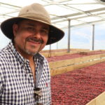 Producer Cristian Rodriguez standing in front of his drying beds co-funded by Project Origin