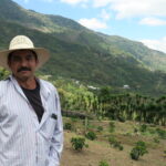 Coffee producer Pedro Erazo standing in front of his newly planted coffee farm Honduras