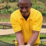 Rwanda coffee producer Venuste Mugiraneza presenting clean washed process green beans at Tumba washing station Rwanda