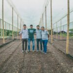 Producers standing in drying tents at coffee collective El Puente in Colombia