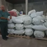 Coffee producer Adalid Caballero with coffee sacks from La Leona