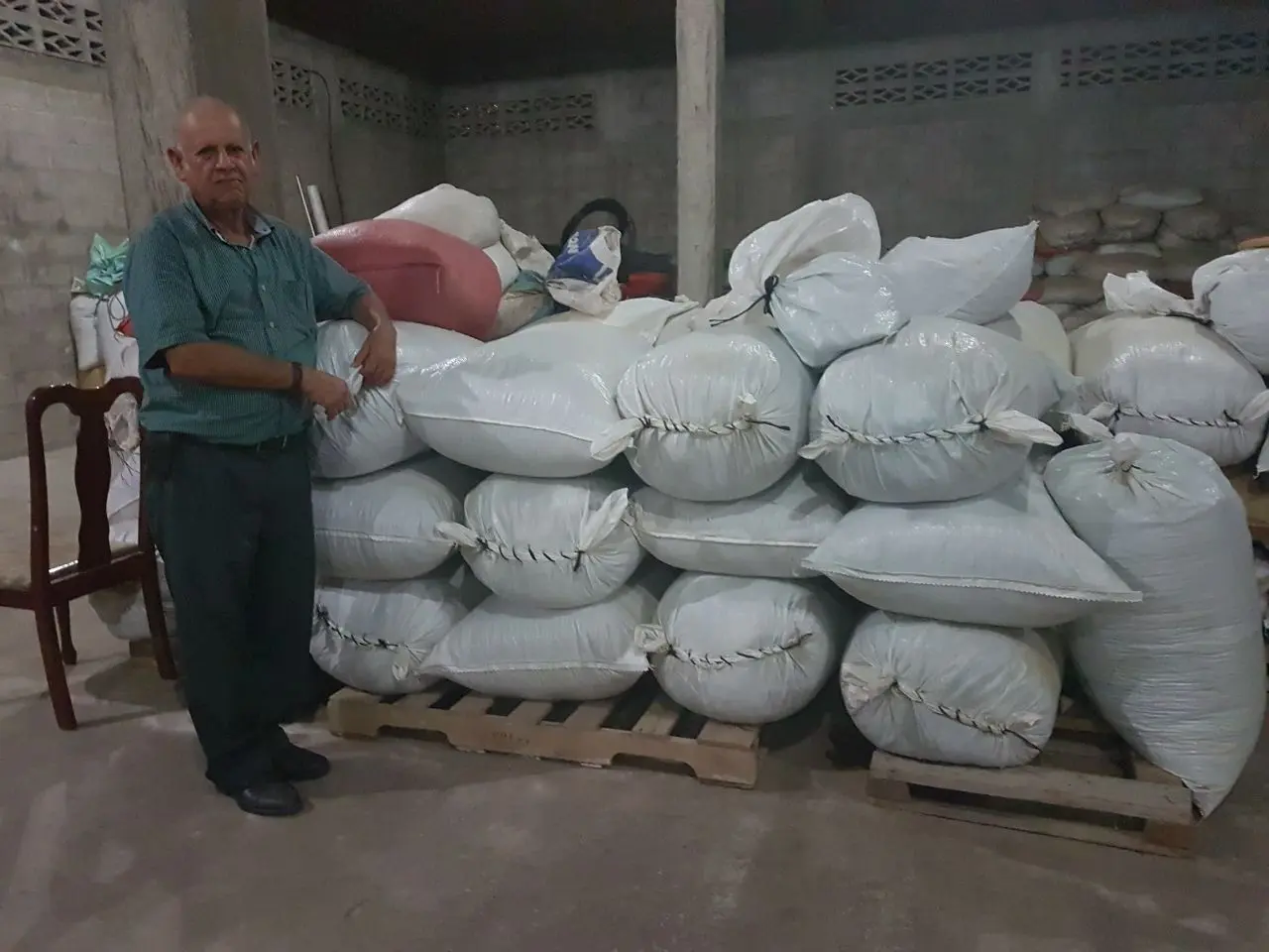 Coffee producer Adalid Caballero with coffee sacks from La Leona