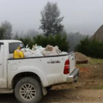 A ute full of coffee sacks driving through a village in Timor-Leste